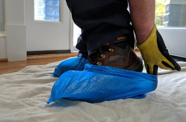 Man putting blue bag over boots 