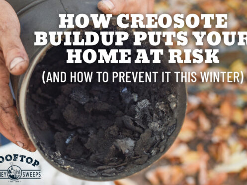 Hand holding a chimney pipe filled with dark creosote buildup during inspection.